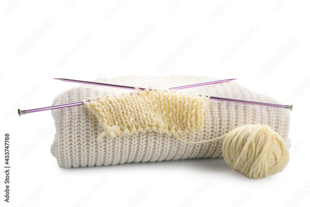 Yarn with knitting needles and plaid on white background