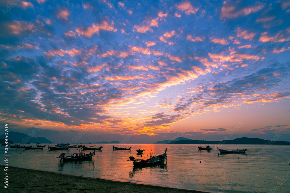 热带海洋中的长尾船和旅游船美丽的风景日出或日落天空