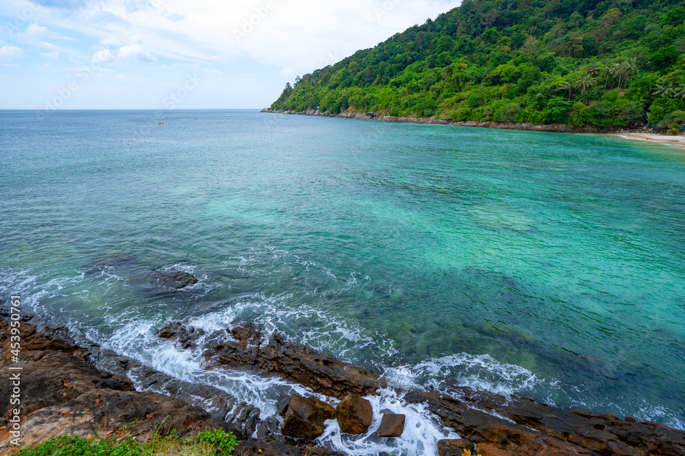 晴朗的蓝天下的岩石海岸，云层海面背景美丽的大海和小岛