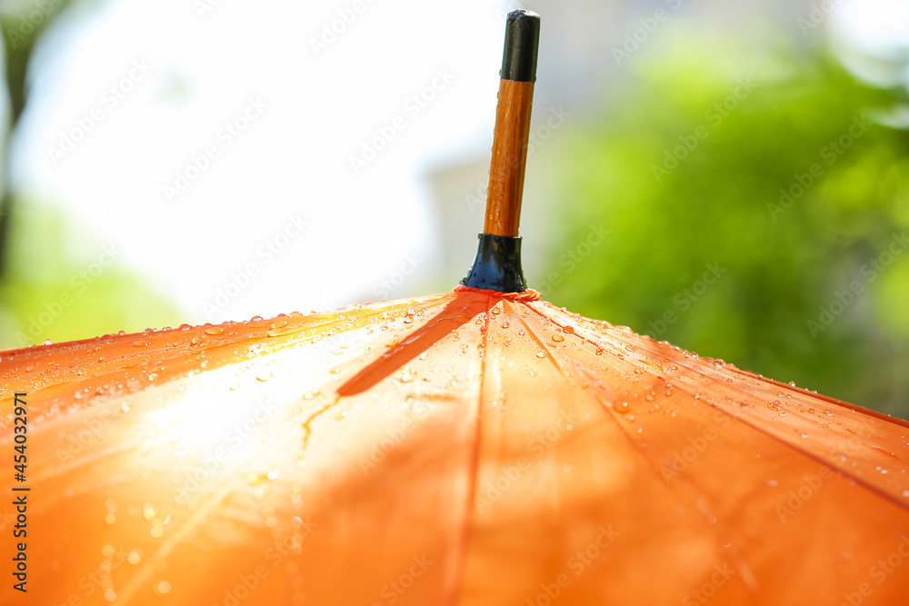 Open umbrella with rain drops outdoors