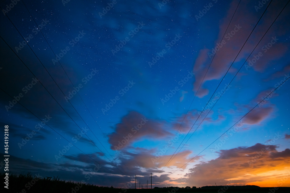 乡村景观上方的夜空，星光灿烂。Rur上方多云