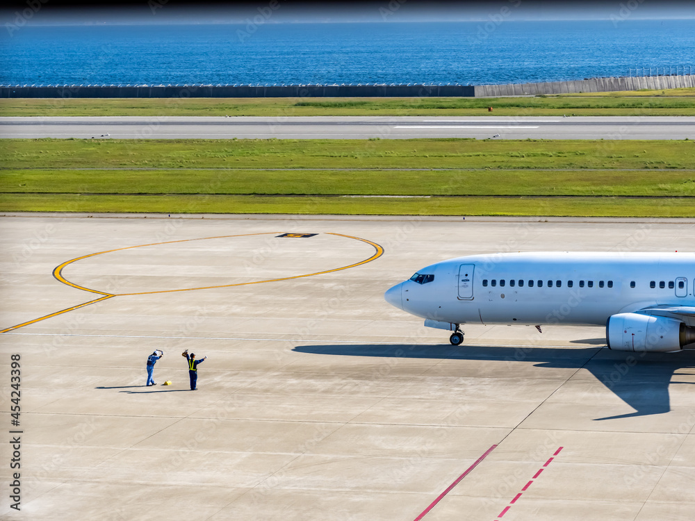 出発する飛行機を見送るスタッフ