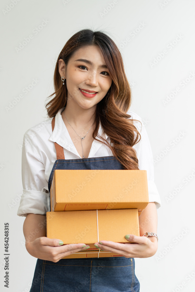 Happy Asian woman holding package parcel box on white background, Delivery courier and shipping serv