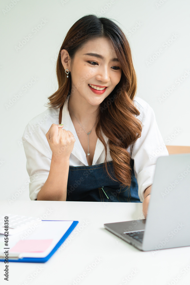 Young smiling beautiful owner asian woman freelance sme business online shopping working on laptop c