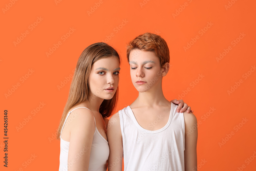 Teenagers with dyed eyebrows on color background