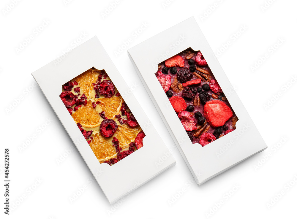 Handmade chocolate bars with fruits, berries and nuts on white background