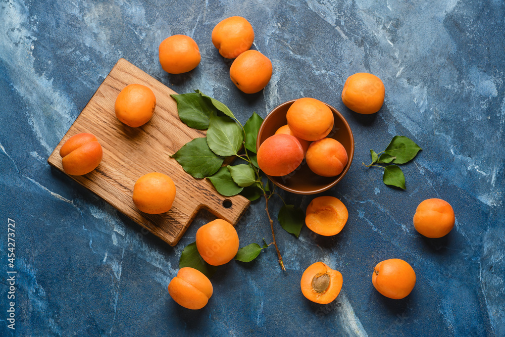 Bowl with tasty ripe apricots on color background