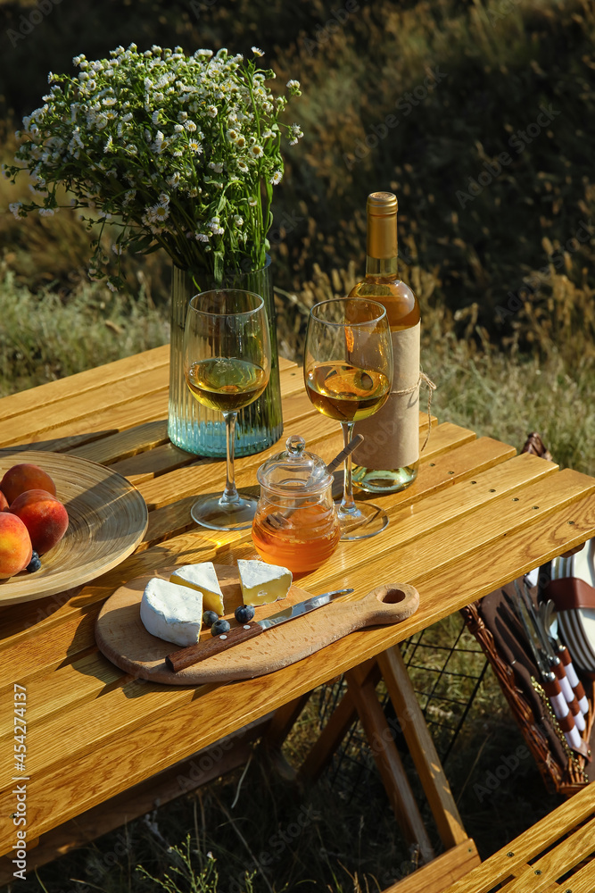 Tasty food and drink for romantic picnic on table outdoors