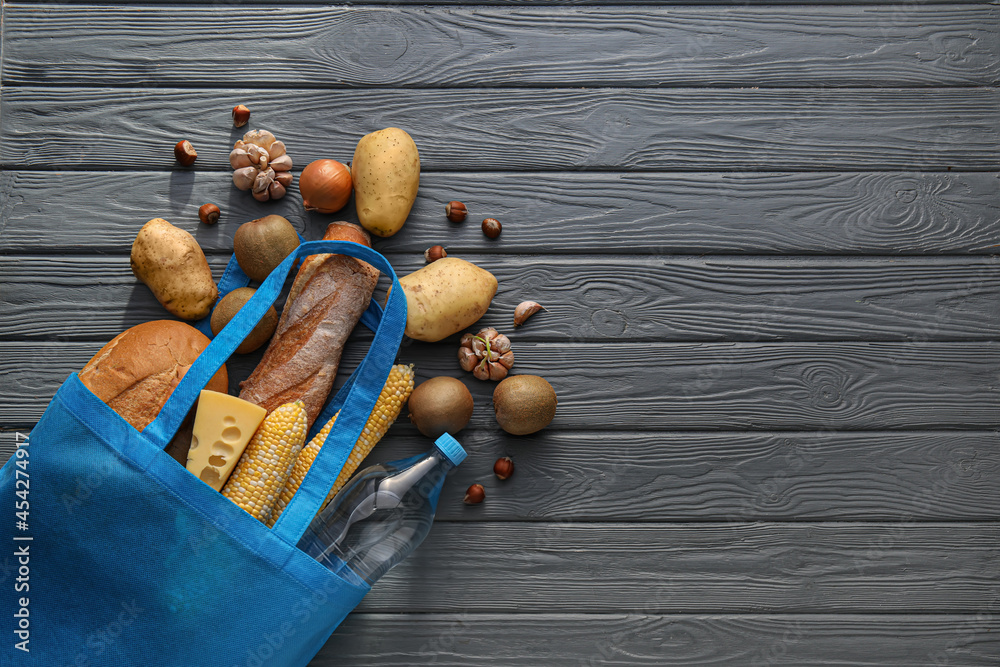 Eco bag with different products on wooden background