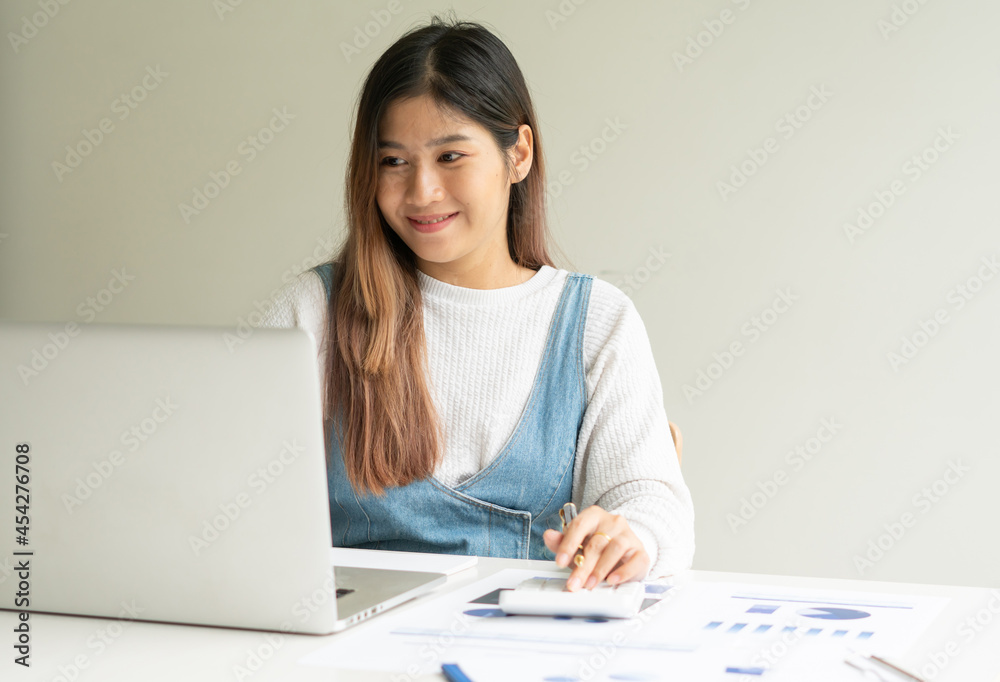 business woman working on laptop computer with business graph