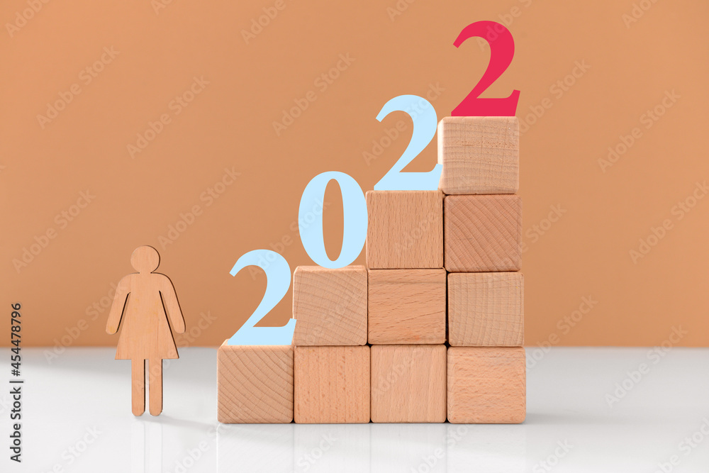 Wooden cubes with figure 2022 on color background