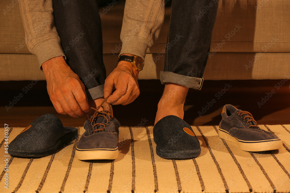 Man wearing soft slippers at home, closeup