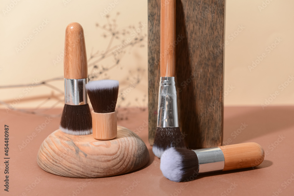 Set of makeup brushes with decor on color background