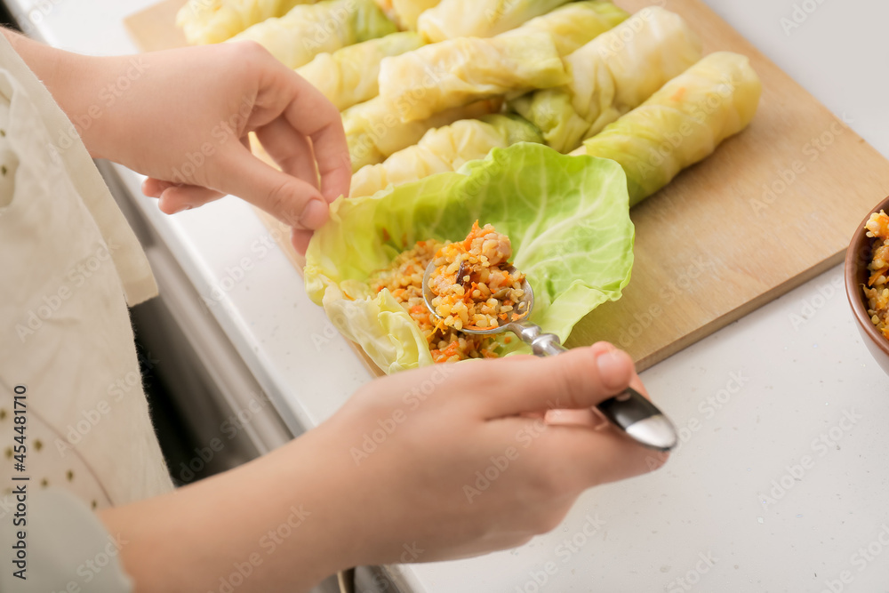 一位女士在厨房的桌子上准备美味的卷心菜馅卷，特写镜头