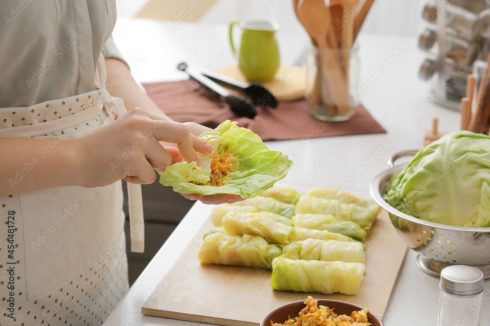 一位女士在厨房的桌子上准备美味的卷心菜馅卷，特写镜头