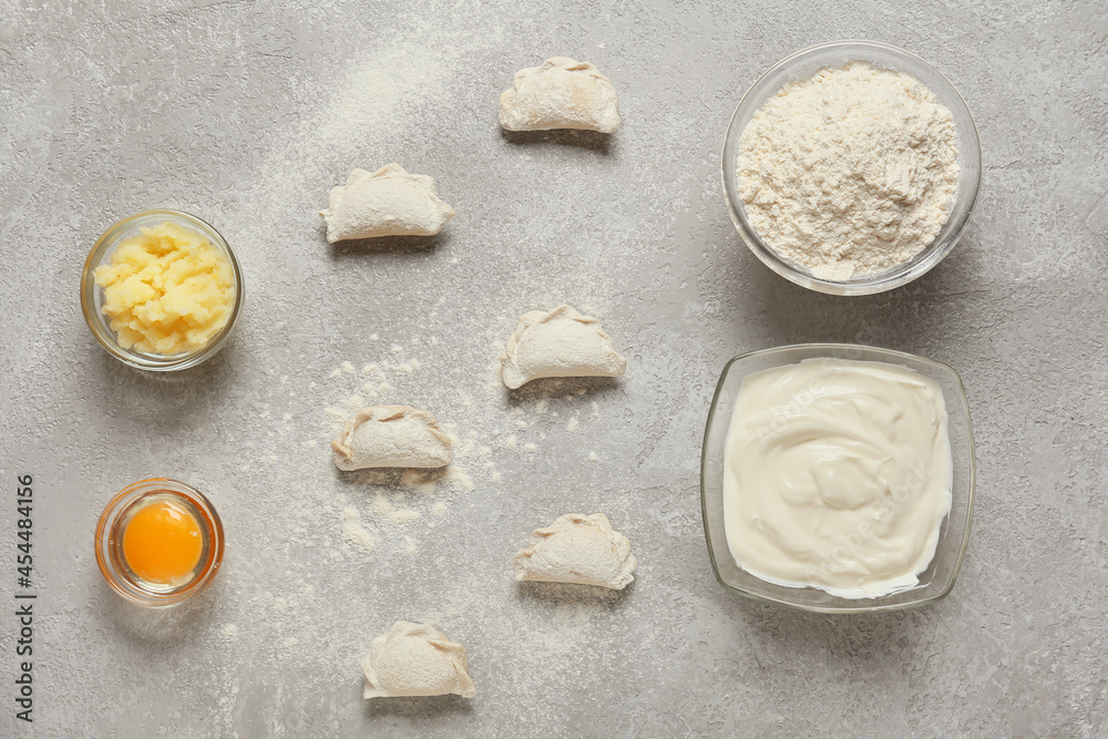 Composition with raw dumplings on grey background