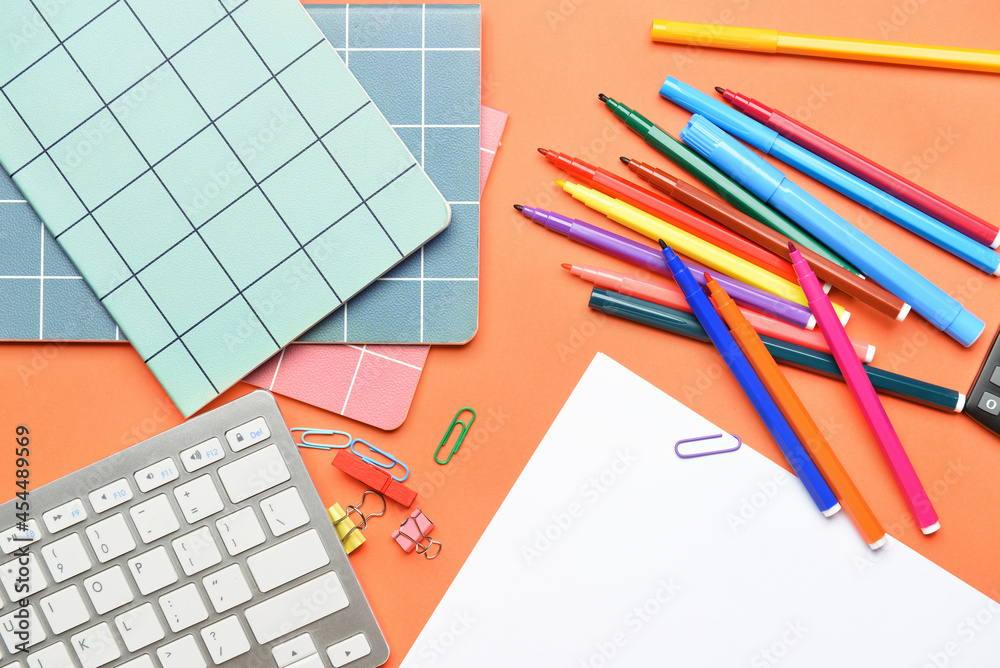 Set of stationery and keyboard on color background