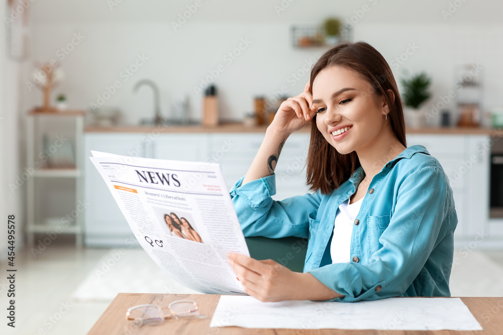 Young woman reading newspaper at home