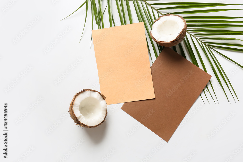 Composition with blank cards, coconut and palm leaf on white background