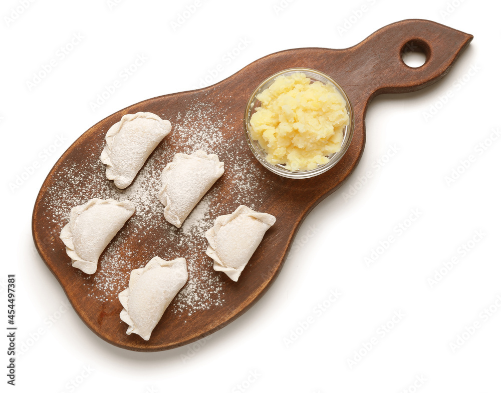 Wooden board with raw dumplings and stuffing on white background