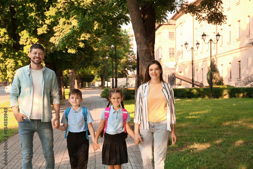 Cute little children going to school with their parents