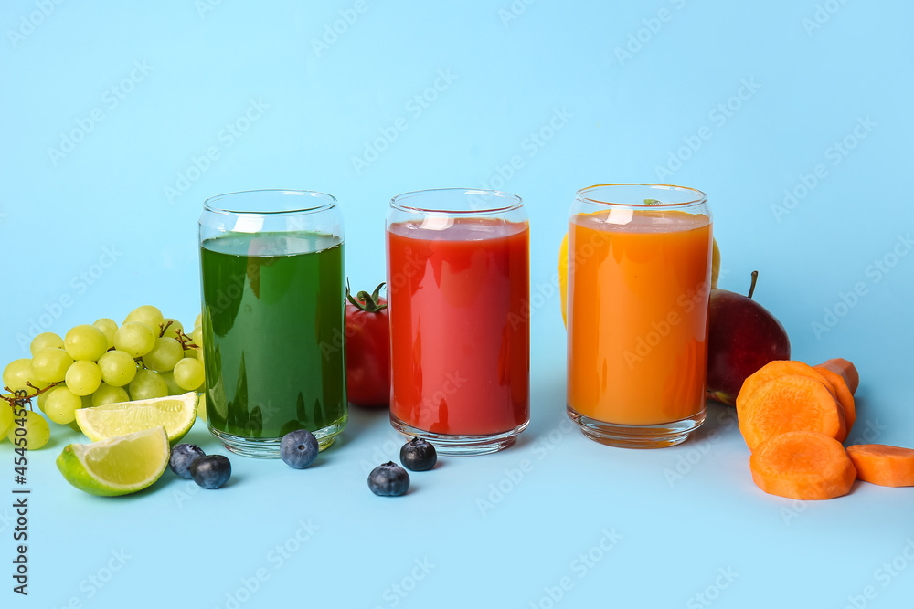 Glasses with healthy juice, fruits and vegetables on color background