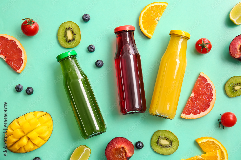 Bottles with healthy juice, fruits and vegetables on color background