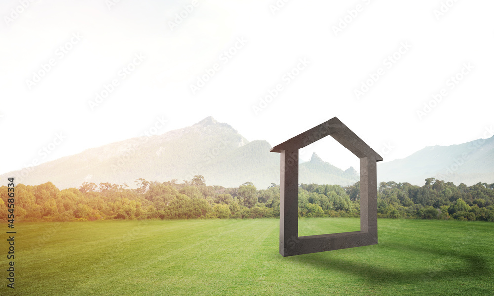 Conceptual background image of concrete home sign on green grass