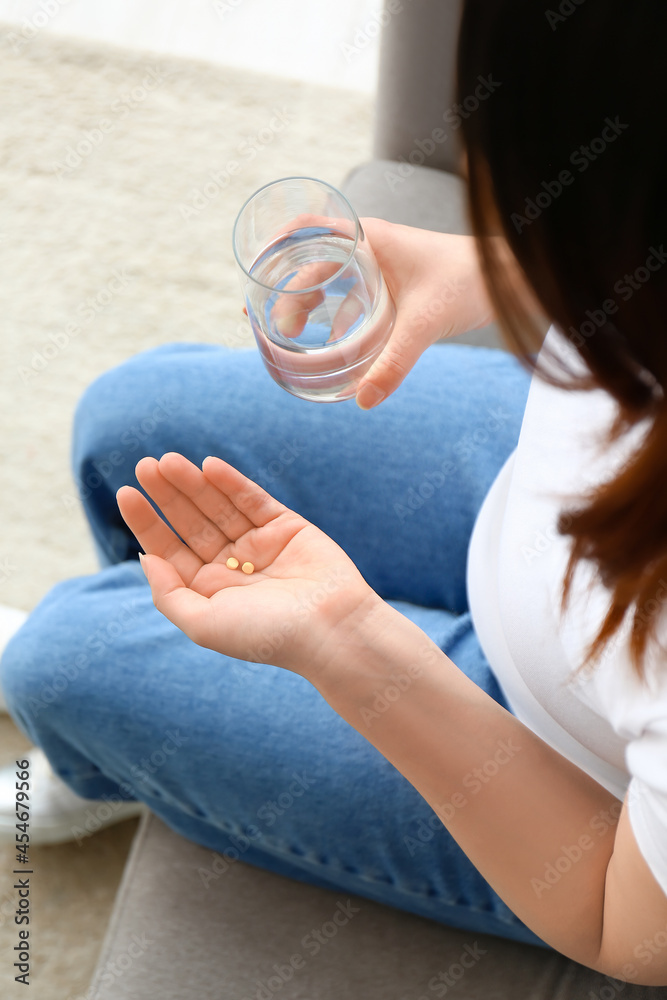 家里有药片和一杯水的年轻孕妇