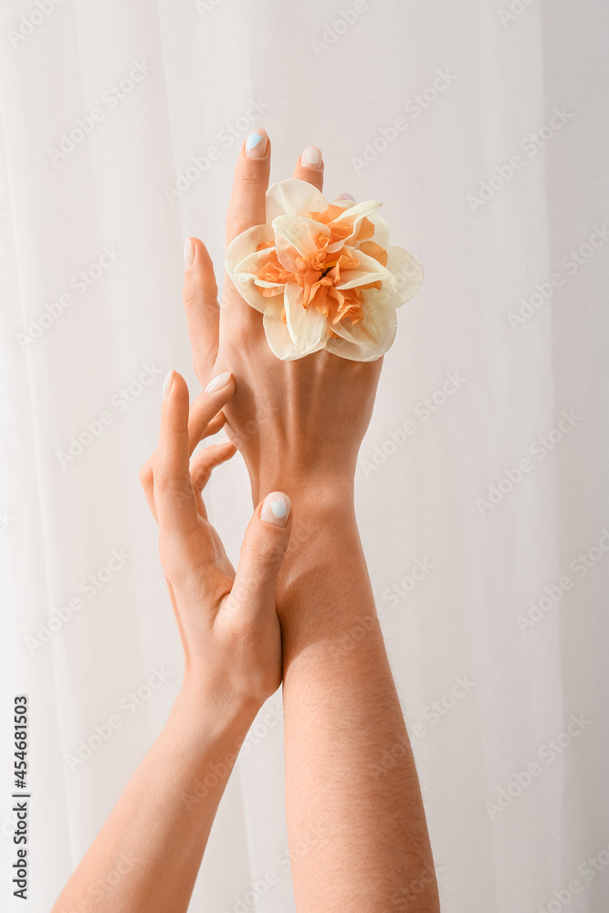 Woman with beautiful manicure and flower on light background