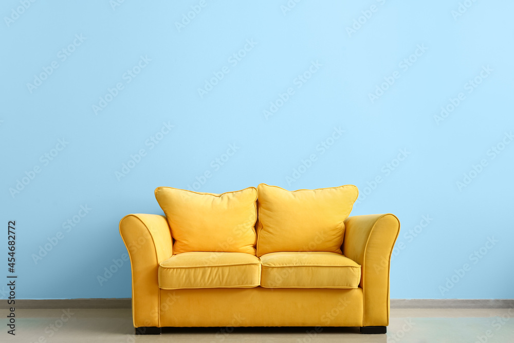 Comfortable sofa near color wall