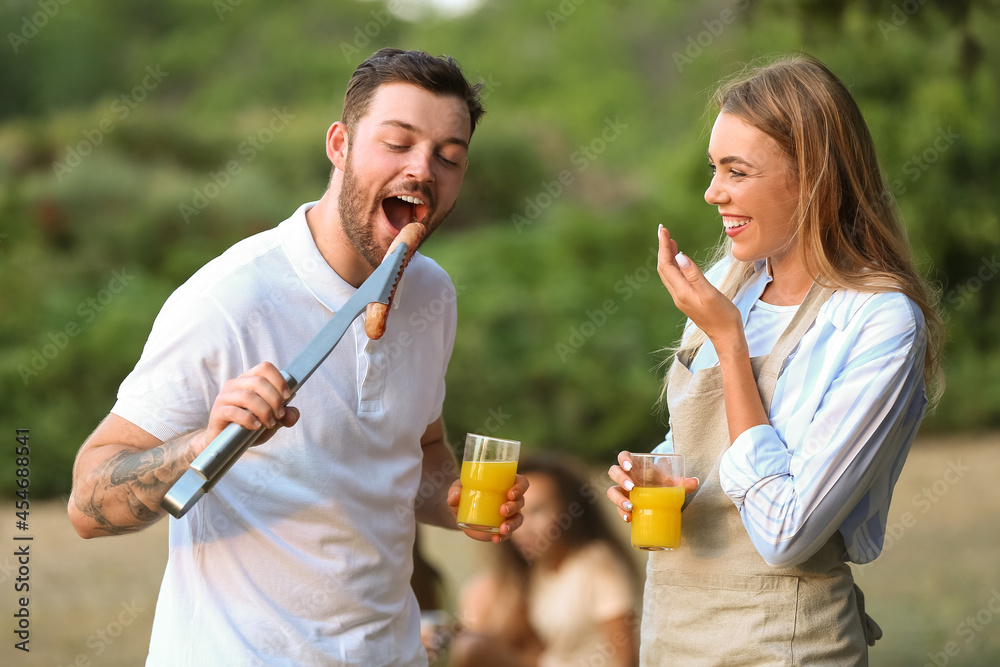 夏日烧烤派对上吃烤香肠的年轻人