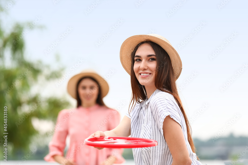 美丽的年轻女子在户外玩飞盘