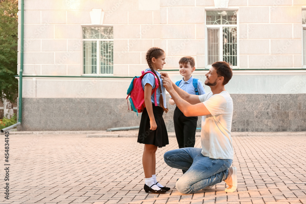 可爱的小孩和他们的父亲一起上学