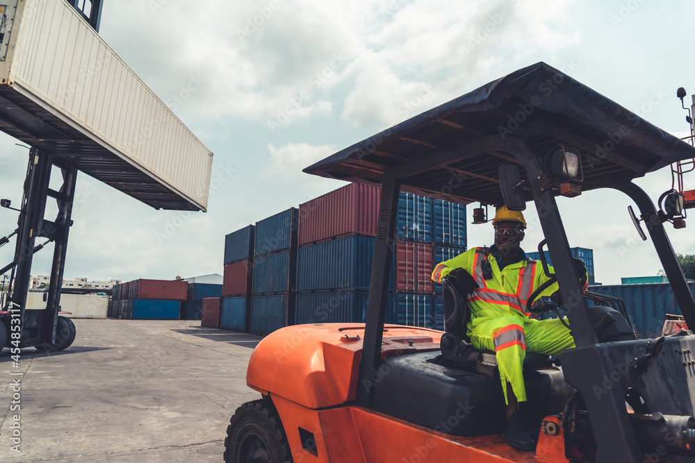 African american man driving forklift in shipyard . Logistics supply chain management and internatio