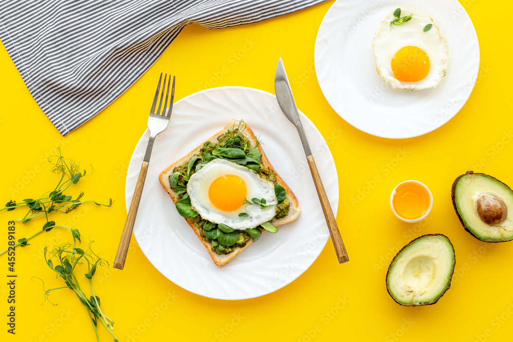 Open sandwich with avocado spinach cream and eggs. Top view