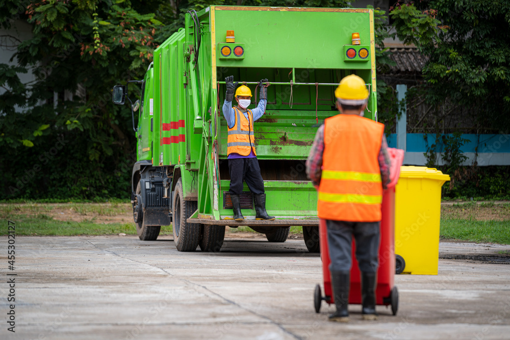 Rubbish cleaner man working with green garbage truck loading waste and trash bin at city,Waste colle