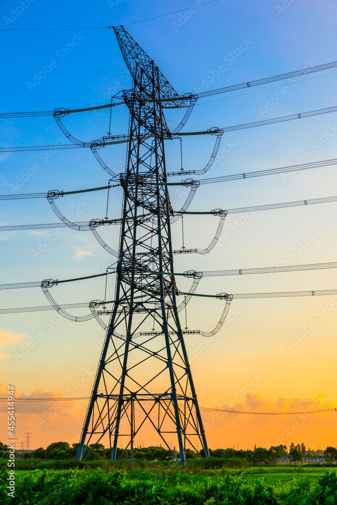 High voltage power tower industrial landscape at sunrise,urban power transmission lines.