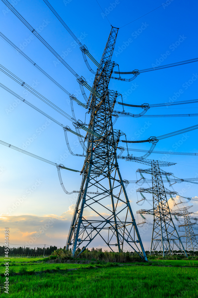 High voltage power tower industrial landscape at sunrise,urban power transmission lines.