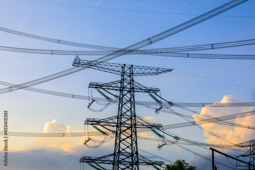 High voltage power tower industrial landscape at sunrise,urban power transmission lines.