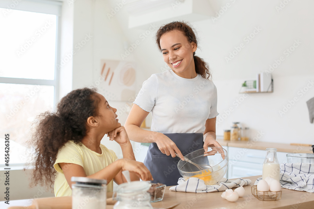 非裔美国小女孩和她的妈妈在厨房做饭