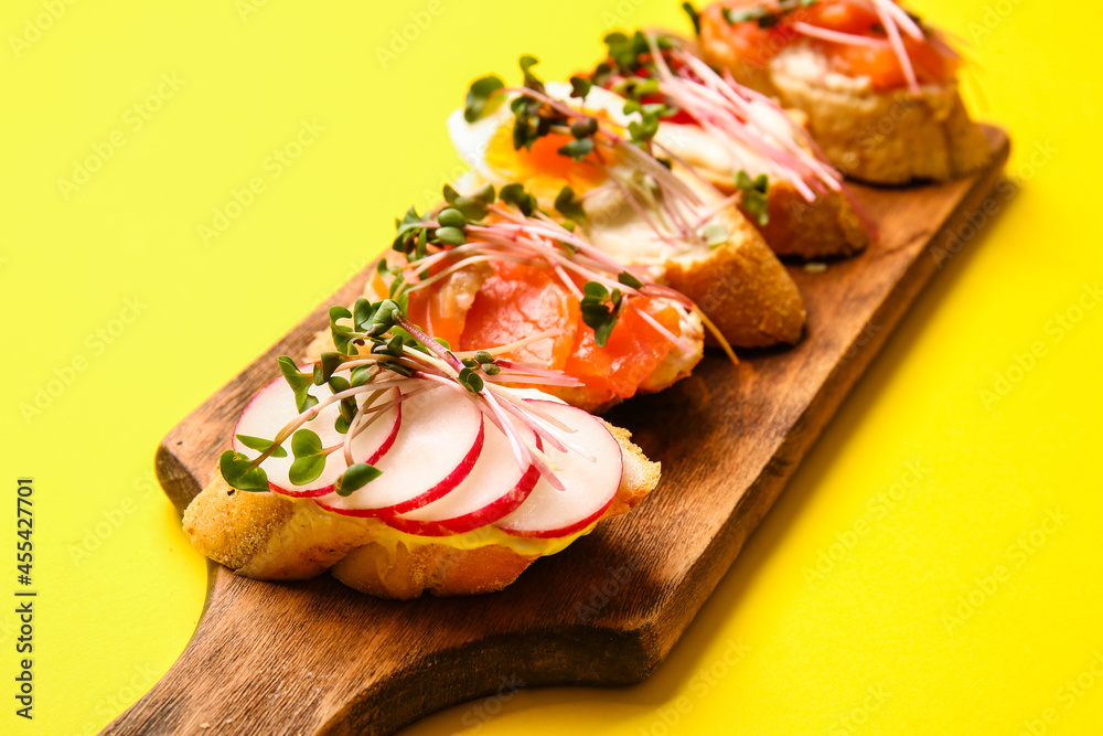 Different bruschettas with micro green on color background, closeup