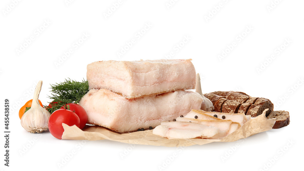 Pieces of salted lard with fresh vegetables on white background