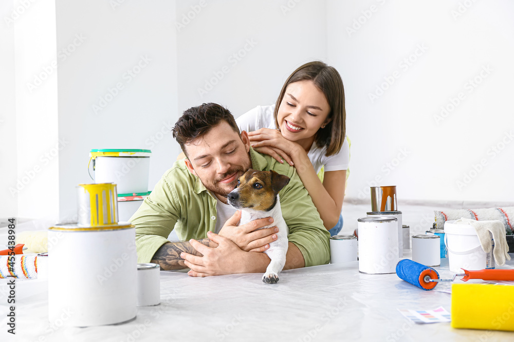 Young couple with cute dog resting during repair of their new house