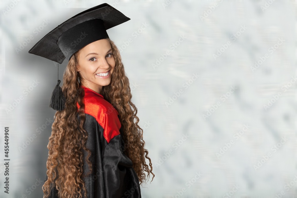 穿着毕业袍和毕业帽获得硕士学位的研究生女孩