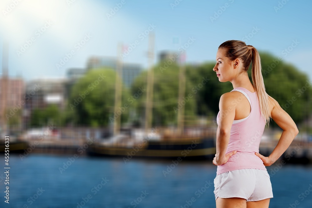 Outdoor shot of young sports woman running along the seashore in morning.