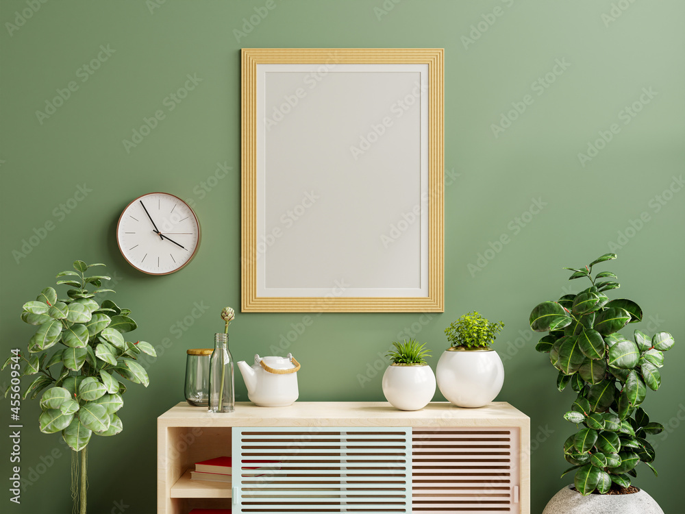 Mockup photo frame green wall mounted on the wooden cabinet with beautiful plants.