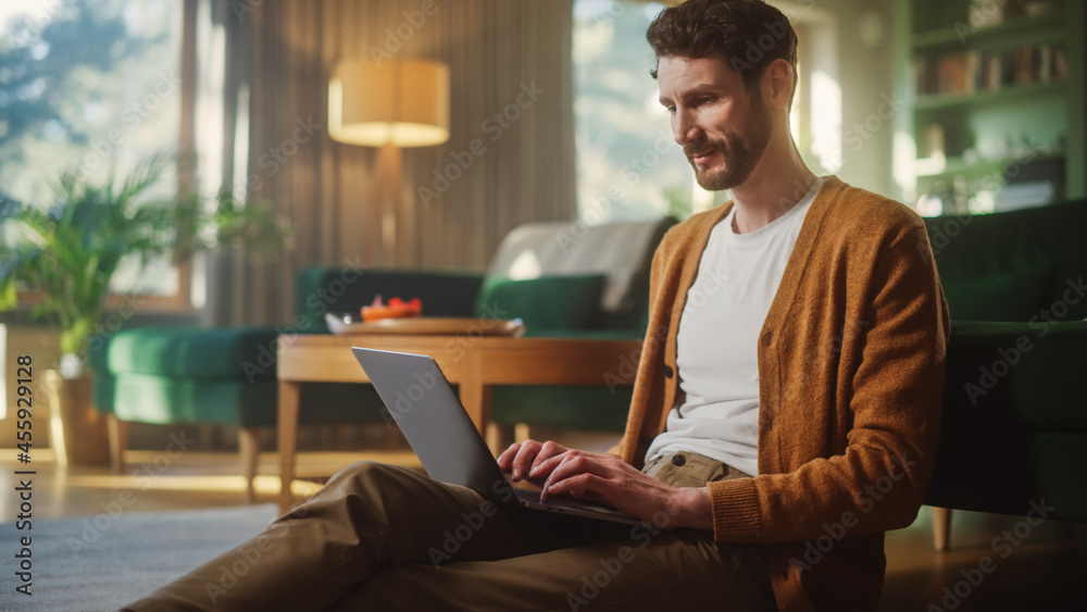 Handsome Happy Man Using Laptop at Home for Remote Work. Early Middle Aged Male Sitting on the Floor