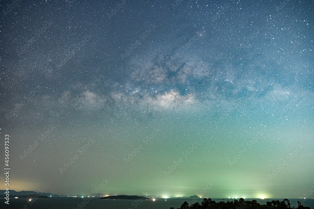 五彩缤纷的银河和山上的绿光的夜景，群山环绕的星空