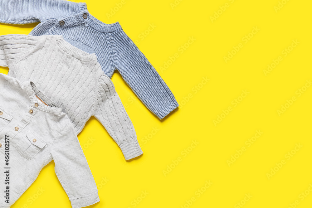 Stylish baby clothes on color background